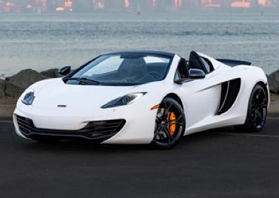 White convertible sports car parked by a waterfront